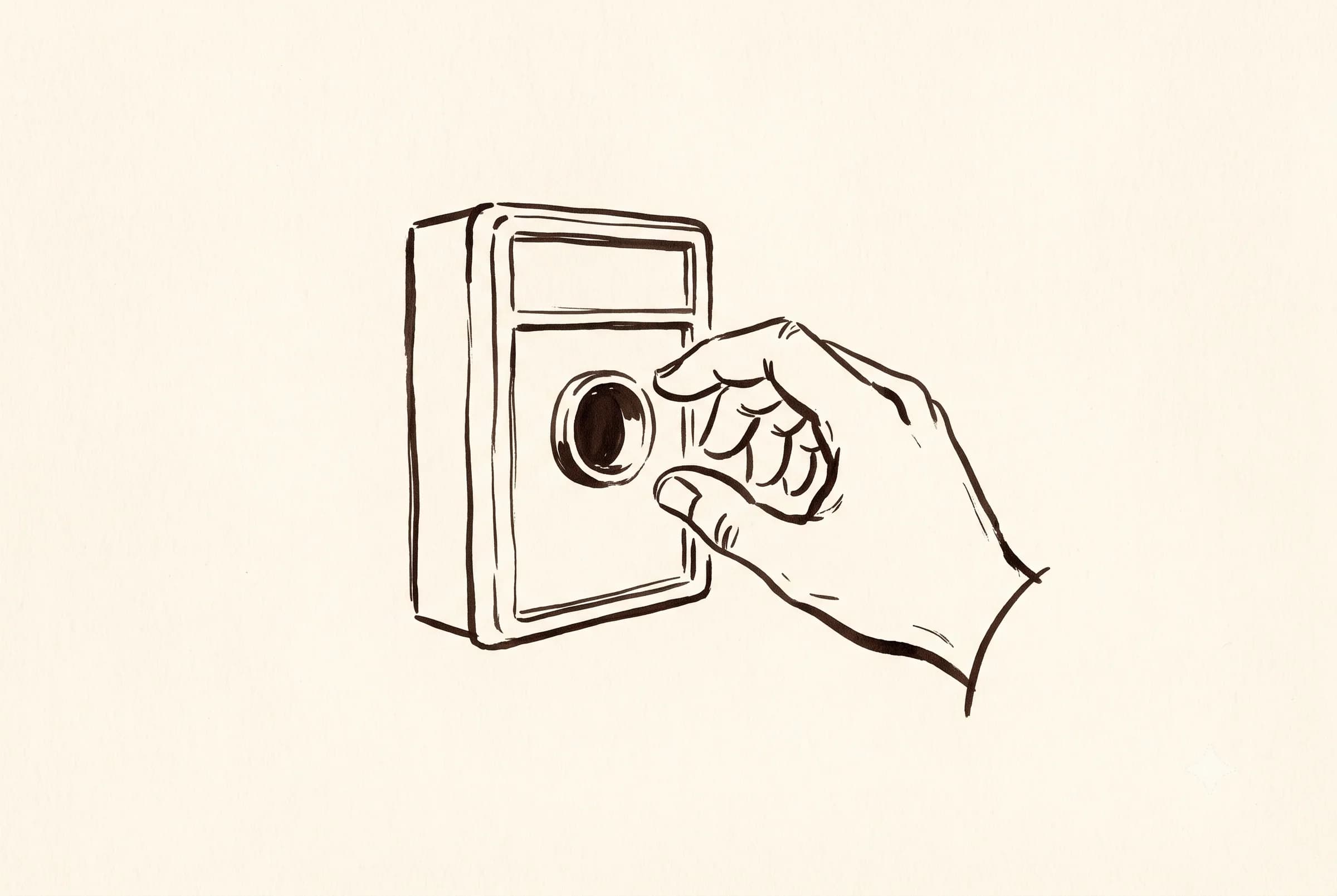 A wall-mounted alarm box with the pull handle missing and a hand reaching for it
